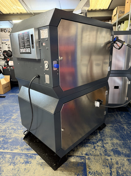 A gray BOSS BOYS pressure washer with model number BBSD12100 displayed on the front panel, situated in an industrial setting.